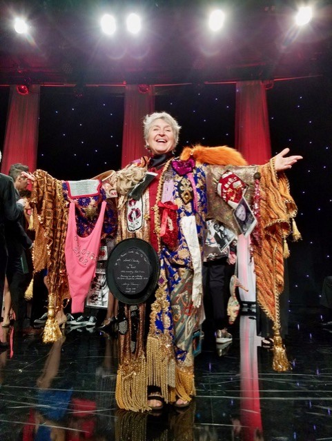 Joanne DiVito on stage with arms outstretched, wearing the Gypsy Robe
