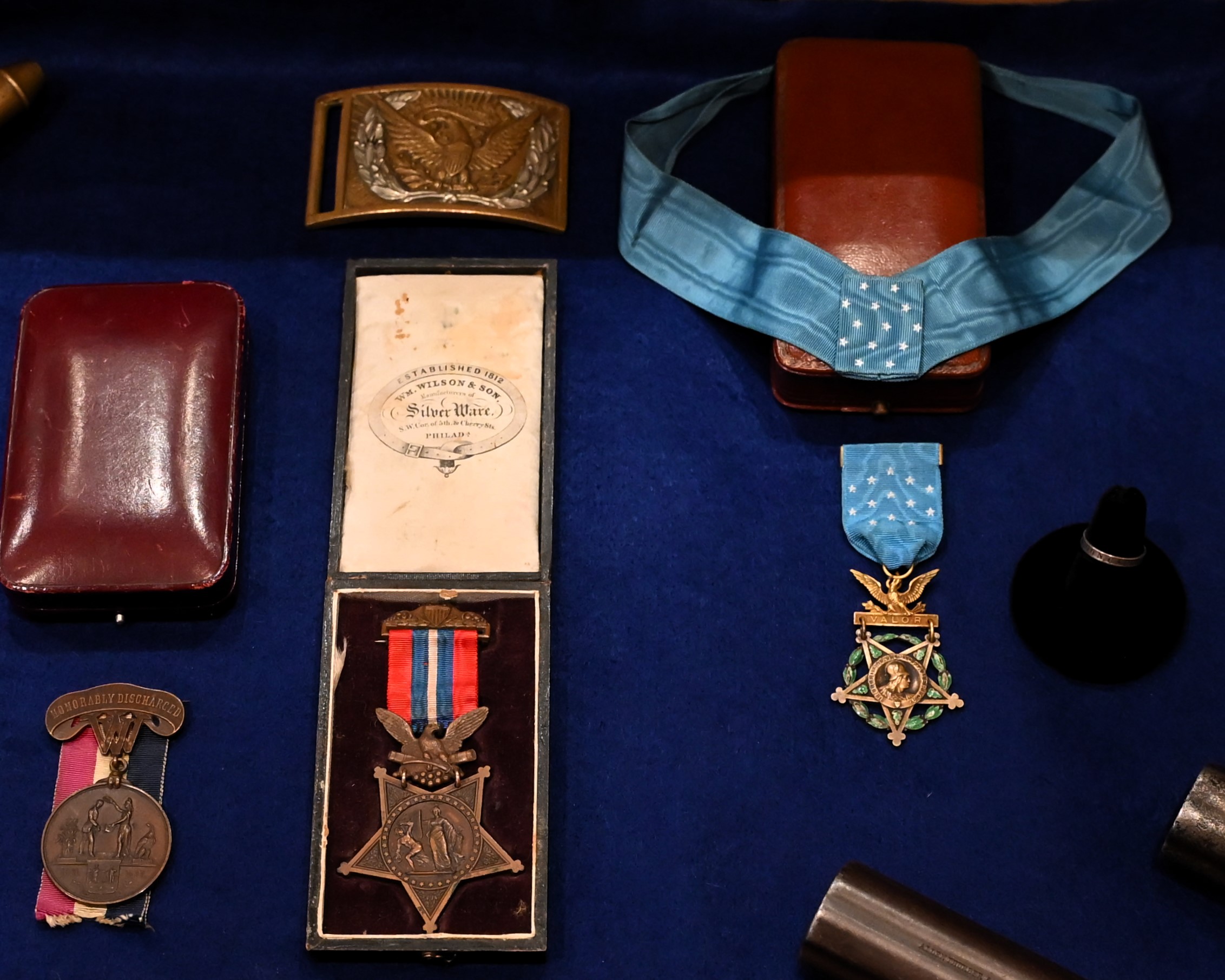 Civil War-era Medals of Honor and a belt buckle displayed in cases
