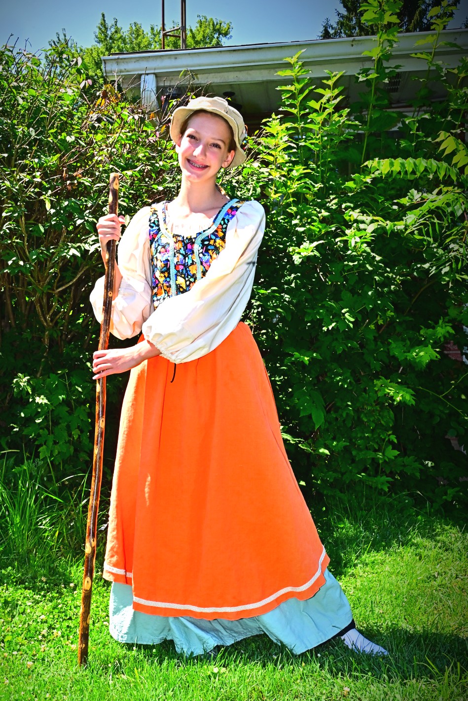 A young festival-goer in an orange skirt and embroidered bodice made by Denise