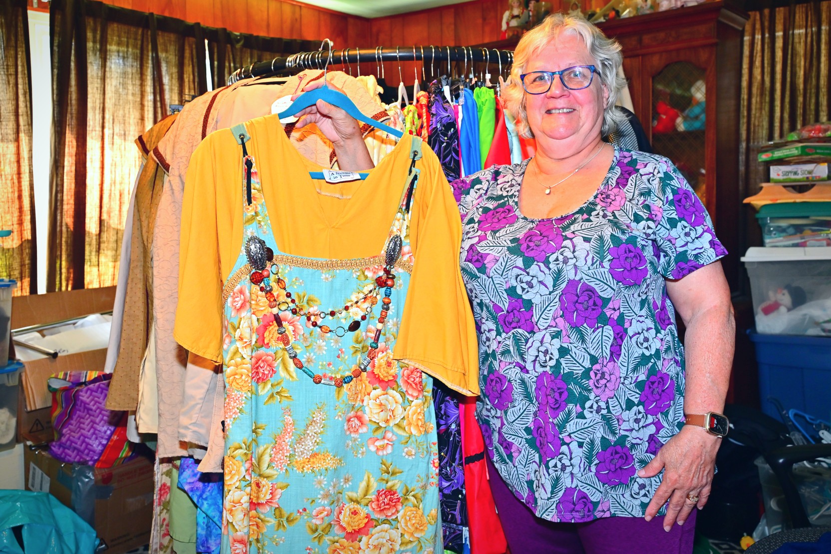 Denise Hazlett standing beside racks of her handmade costumes