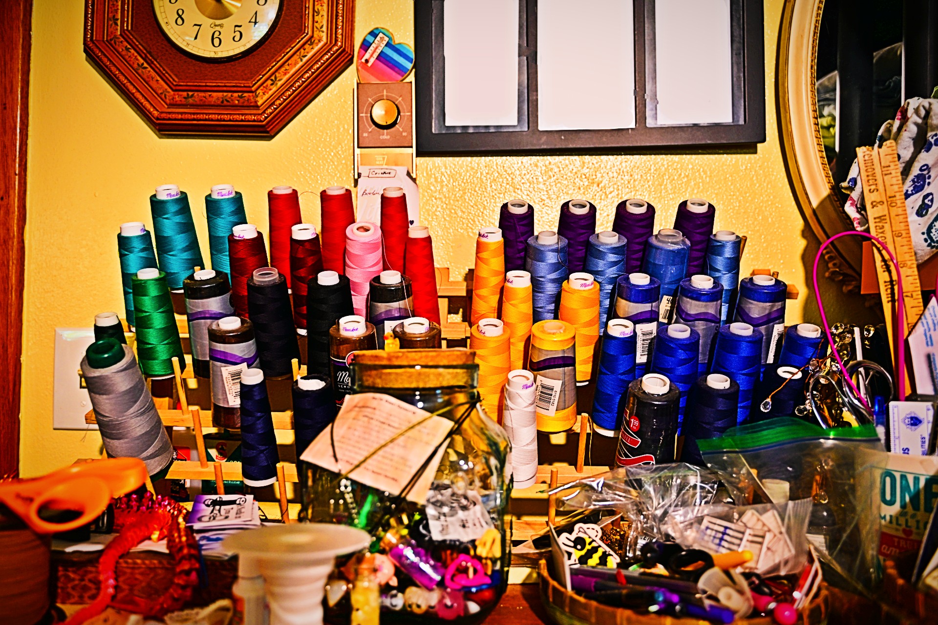 Spools of colorful thread lining the wall of Denise's sewing room