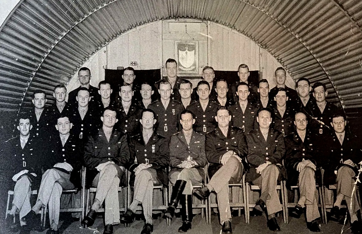 Members of the 63rd Signal Battalion seated inside a Quonset hut