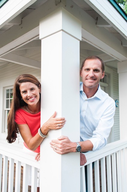 Emily and Steve Wieringa leaning around a white porch column